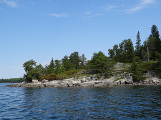 Rocky shore slopes gently into clear waters